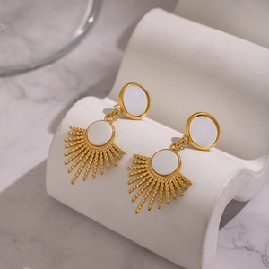 Macro shot of French vintage gold sun drop earrings with elegant natural shell inlay detail