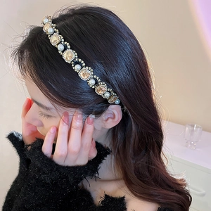 Detailed view of elegant pearl and champagne crystal headband on a fashion model