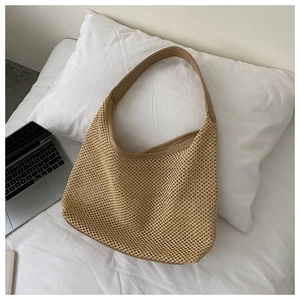 Detail of khaki woven straw hobo bag with a soft texture and brown PU leather shoulder strap