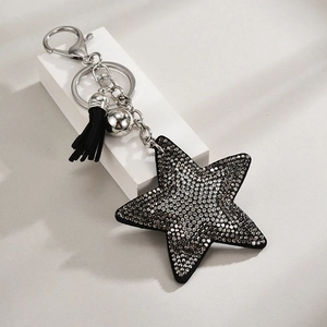 Close-up of black star keychain with sparkling rhinestones, silver hardware and tassel