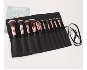 Close-up of professional 12pcs makeup brushes with rose gold ferrules in black PU leather roll bag