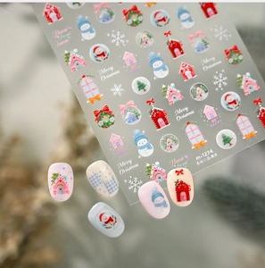 Gros plan de stickers à ongles de Noël avec motifs de maisons enneigées et bonhommes de neige