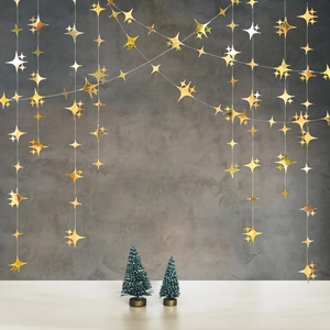 Dettaglio di ghirlande a stelle dorate appese per decorazioni di feste e matrimoni