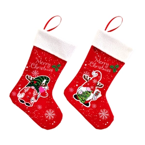 Detail of red felt Christmas stockings with gnome patterns and Merry Christmas text