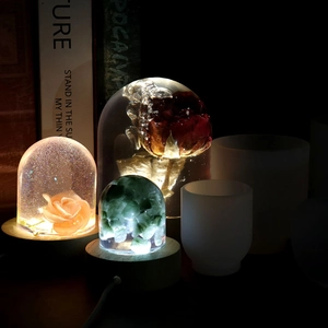 Detail view of crystal resin night lights with roses and stones on wood bases