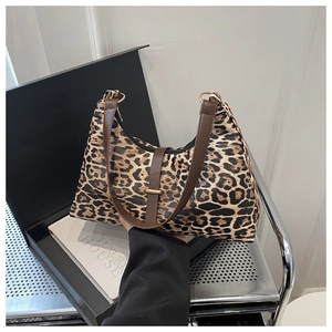 Detail der Handtasche mit Leopardenmuster und braunem Riemen auf einer Geschenkbox