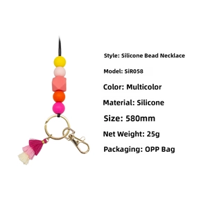 Detail of colorful silicone bead necklace with gold key ring and pink tassel accent