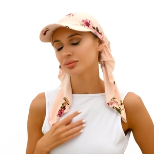 Close-up of pink floral sun hat with ribbon tie detail on female model
