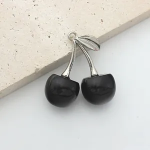 Detailed view of handmade black crystal cherry charm with silver metal leaf and loop