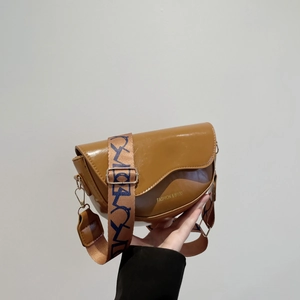 Brown PU leather saddle bag with wide patterned strap and Fashion & Bags text on white background