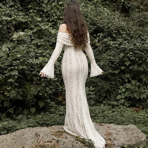 Dettaglio di un elegante abito in pizzo bianco con maniche a campana e schiena scoperta