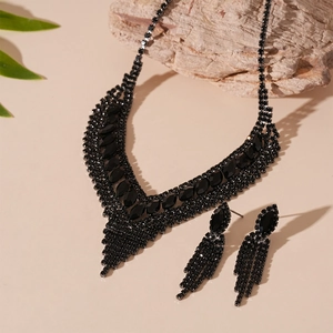 Detail view of gothic style black V-shaped tassel necklace and rhinestone earring set