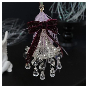 Detailed shot of crystal chandelier ornament with burgundy velvet bow and purple feathers
