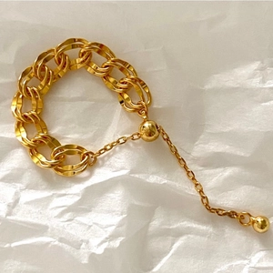Minimalist adjustable double-loop gold chain ring with polished bead on white background