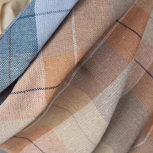 Detailed close-up of plaid fabric texture with blue and beige woven cotton linen material
