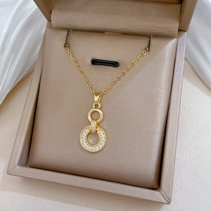 Detailed view of gold interlocking rings necklace with shimmering pavé crystal accents