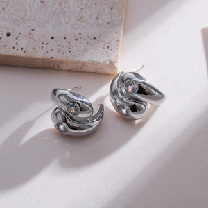 Macro shot of silver streamlined double-layer earrings with sparkling zircon stones