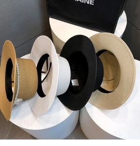 Detail of elegant straw boater hats in four colors with pearl and floral decorations
