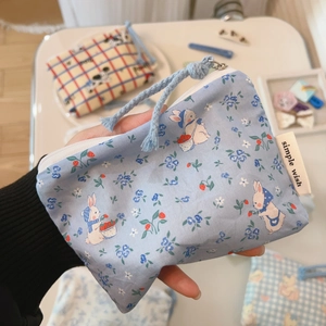 Close-up of cute rabbit and blue floral pattern on mini cotton storage pouch