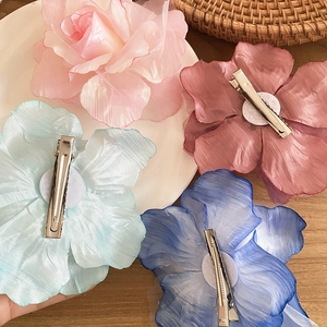 Vue détaillée de pinces à cheveux fleurs en maille colorées en rose bleu et vieux rose
