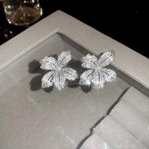 Close-up of elegant silver flower stud earrings with shimmering micro-pave crystals