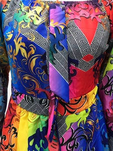 Detailed view of baroque floral print dress with satin finish and greek key patterns
