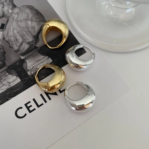 Detail of chunky teardrop hoop earrings in polished gold and silver finishes