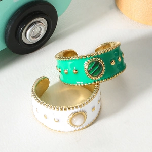 Detail of green and white enamel open rings with natural stones and gold beaded edges