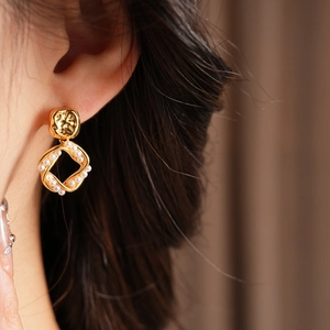 Close-up of model wearing vintage gold plated square hoop earrings with pearl drops