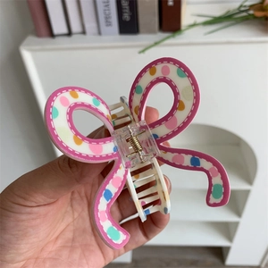 Detail of butterfly hair claw clip with colorful polka dots and white stitch pattern