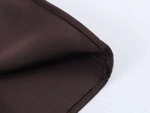 Gros plan détaillé du tissu en satin marron foncé avec coutures doubles de précision