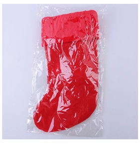 Detail of red Christmas stocking with knitted cuff in clear packaging for holiday gifts