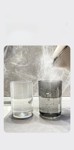 Heat-resistant PET toothbrush cups in clear and smoke gray shown with hot water