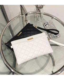 Detailed close-up of black and white quilted PU leather handbags with gold metal hardware