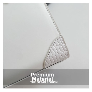 Detailed macro view of white leather bag corner with crocodile embossed texture stitching