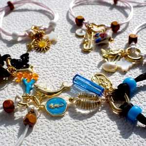 Handmade woven charm bracelets with sea-themed pendants like seahorses and shells