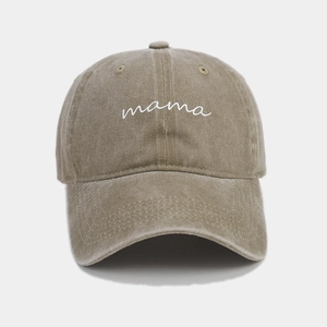 Detailed view of mama script embroidery on khaki washed cotton baseball cap texture