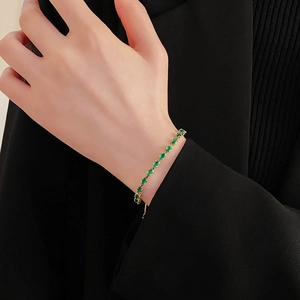 Close-up of elegant green gemstone bracelet with gold plating on a model wrist