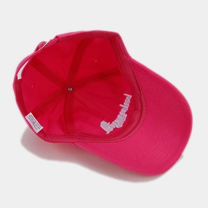 Inside view of rose red cotton baseball cap showing stitching and 100% cotton label