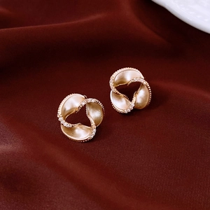 Macro shot of 14K gold plated spiral flower earrings with diamonds on red silk