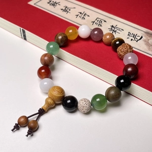 Macro view of multi-gemstone prayer beads resting on a traditional red poetry book