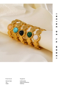 Detailed shot of vintage gold-plated rings with colorful gemstones on cream silk fabric