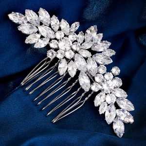 Détail d'un peigne à cheveux de mariée en argent avec zircone sur fond satin bleu