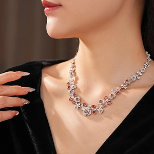 Detail of vintage necklace with orange-brown gemstone and zircon floral accents