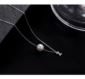 Close-up of white round pearl and sparkling zircon-encrusted letter Z on silver chain