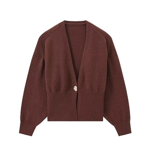 Close-up of dark brown knit cardigan texture with detailed ribbed cuff and metal button
