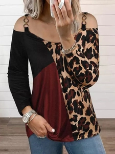 Detail of cold shoulder long sleeve shirt with leopard print and golden ring strap accents
