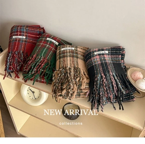 Detailed view of checkered scarves with fringe tassels in four vintage color patterns
