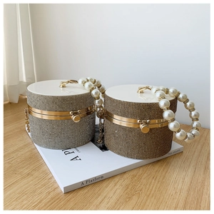 Detailed view of silver and gold evening bags with pearl handles and crystal rhinestones