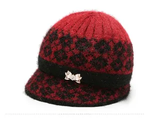 Detail of red floral knit hat featuring a rhinestone bow and textured faux fur finish